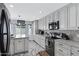 Bright kitchen with white cabinets, granite countertops, mosaic backsplash, and stainless steel appliances at 5020 E Dallas St, Mesa, AZ 85205