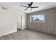 Bright bedroom with modern ceiling fan, light-colored wood-look flooring, and paneled accent wall at 520 N Stapley Dr # 166, Mesa, AZ 85203