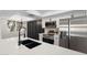 Modern kitchen featuring stainless steel appliances, white cabinets, and a large quartz countertop island with a black sink and faucet at 520 N Stapley Dr # 166, Mesa, AZ 85203