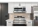Close up of a modern stainless steel stove, microwave, white cabinets, and quartz countertops in a stylish kitchen at 520 N Stapley Dr # 166, Mesa, AZ 85203