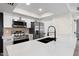 Contemporary kitchen featuring stainless steel appliances, white cabinets, a quartz countertop island, and a black sink with faucet at 520 N Stapley Dr # 166, Mesa, AZ 85203