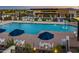 Spacious community pool area with umbrellas, lounge chairs, and a splash fountain, ideal for Gathering fun and relaxation at 5250 S Wesley Cir, Mesa, AZ 85212