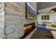 Close up of a stone fireplace with TV, comfortable seating, and stylish lighting fixtures in the resident lounge at 5250 S Wesley Cir, Mesa, AZ 85212