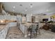 Well-lit, open kitchen with white cabinets, stainless steel appliances, a large island, and a view of the living area at 5250 S Wesley Cir, Mesa, AZ 85212