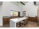 Sleek, modern kitchen features a large island, stylish countertops, and expansive windows overlooking the community at 5250 S Wesley Cir, Mesa, AZ 85212