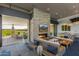 Comfortable lounge area with a stone fireplace, plush couches, and open access to a patio overlooking the golf course at 5250 S Wesley Cir, Mesa, AZ 85212