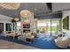 A stylish lounge with comfortable seating, fireplace, TV, modern lighting, and access to an outdoor patio with golf course views at 5250 S Wesley Cir, Mesa, AZ 85212