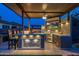 Covered outdoor kitchen with bar seating, built-in grill, a beverage refrigerator, and TV perfect for entertaining guests at 5250 S Wesley Cir, Mesa, AZ 85212