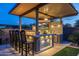 Covered outdoor kitchen with bar seating, built-in grill, a cooler, and TV perfect for entertaining guests at 5250 S Wesley Cir, Mesa, AZ 85212