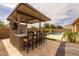 Outdoor kitchen with counter seating, stainless steel grill, and stone accents, enhancing the backyard entertaining space at 5250 S Wesley Cir, Mesa, AZ 85212