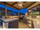 Covered outdoor kitchen with seating, built-in grill, a beverage refrigerator, and TV perfect for entertaining guests at 5250 S Wesley Cir, Mesa, AZ 85212