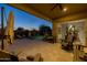 Covered patio overlooking a sparkling pool, outdoor kitchen area, and lush landscaping, creating a private oasis at 5250 S Wesley Cir, Mesa, AZ 85212