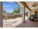 Covered patio with elegant table and chairs with views of green yard, palm trees, and landscaped garden at 5342 S Citrus Ct, Gilbert, AZ 85298