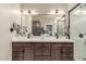 Bathroom featuring double sink vanity, white countertops, dark wood cabinets, and a glass-enclosed shower at 6357 W Potter Dr, Glendale, AZ 85308