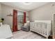 Neutral Bedroom with a crib, glider chair, patterned rug, and rustic window coverings at 6357 W Potter Dr, Glendale, AZ 85308