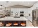 Bright kitchen featuring white cabinetry, stainless steel appliances, a large island with seating and light wood floors at 6357 W Potter Dr, Glendale, AZ 85308
