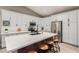 Bright kitchen featuring white cabinetry, stainless steel appliances, a large island with seating, and light wood floors at 6357 W Potter Dr, Glendale, AZ 85308