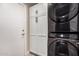 Laundry room featuring a stacked washer and dryer set and white storage cabinets at 6357 W Potter Dr, Glendale, AZ 85308