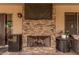 Covered patio features an outdoor stone fireplace with a TV and dining and seating areas at 6357 W Potter Dr, Glendale, AZ 85308