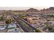 An aerial shot that displays a mix of residential homes, a main road with cars, and open greenery at 6450 E Vernon Ave, Scottsdale, AZ 85257