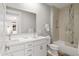 Bright bathroom featuring a double sink vanity, large mirror, and a bathtub with glass doors at 6450 E Vernon Ave, Scottsdale, AZ 85257
