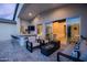 Stylish covered patio with bar seating, comfortable lounge area, a cozy fire pit, and seamless access to indoor spaces at 6450 E Vernon Ave, Scottsdale, AZ 85257