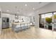 Modern kitchen with stainless steel appliances, a large island, and access to the outdoor patio at 6450 E Vernon Ave, Scottsdale, AZ 85257