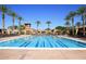 Large community pool with lap lanes, surrounded by palm trees and lounge chairs at 6611 S San Jacinto St, Gilbert, AZ 85298