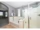 Bright bathroom boasting a soaking tub, glass shower, tile floors and an arched doorway to main bedroom at 6611 S San Jacinto St, Gilbert, AZ 85298
