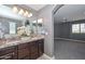 This main bathroom features dual sinks, granite countertops, dark wood cabinets, and arched doorway to the main bedroom at 6611 S San Jacinto St, Gilbert, AZ 85298