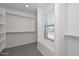 Walk-in closet with carpet flooring, built-in shelving, and a large window with natural light at 6611 S San Jacinto St, Gilbert, AZ 85298