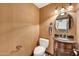 Charming powder room with decorative wallpaper, toilet, and carved wood vanity with a round mirror at 700 N Dobson Rd # 34, Chandler, AZ 85224