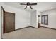 Bedroom with ceiling fan and two doors: one to a closet, one to another room, carpet and white walls at 700 N Dobson Rd # 34, Chandler, AZ 85224
