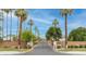Gated community entrance with lush landscaping, palm trees, and secure entry at 700 N Dobson Rd # 34, Chandler, AZ 85224