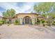 Stunning home entrance with arched doorway, double doors, desert landscaping, and brick paver driveway at 700 N Dobson Rd # 34, Chandler, AZ 85224