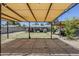 Outdoor living with covered patio over gravel, lush bougainvillea and desert landscaping at 7135 W Flower St, Phoenix, AZ 85033