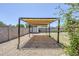 Gravel backyard features a covered patio area with desert landscaping, and a storage shed at 7135 W Flower St, Phoenix, AZ 85033