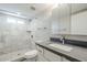 Bright bathroom featuring a marble tiled shower and a modern vanity with stone countertop at 7135 W Flower St, Phoenix, AZ 85033