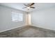 Bedroom featuring ceiling fan, neutral carpet, white walls, and blinds covering the window at 7135 W Flower St, Phoenix, AZ 85033