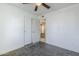 Neutral bedroom featuring gray carpet, white walls, ceiling fan, and double door closet at 7135 W Flower St, Phoenix, AZ 85033