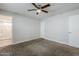 Neutral bedroom featuring gray carpet, white walls, ceiling fan, and an attached bathroom at 7135 W Flower St, Phoenix, AZ 85033