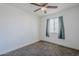 Bedroom featuring ceiling fan, neutral carpet, white walls, and curtains covering the window at 7135 W Flower St, Phoenix, AZ 85033