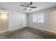 Bedroom featuring ceiling fan, neutral carpet, white walls, and a window at 7135 W Flower St, Phoenix, AZ 85033