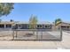 Inviting single-story home with a well-maintained gray exterior, gravel landscaping, and gated front yard at 7135 W Flower St, Phoenix, AZ 85033