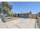 Charming single-story home featuring a gray exterior, spacious driveway, and secure fenced front yard at 7135 W Flower St, Phoenix, AZ 85033