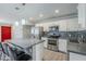 This updated kitchen features stainless steel appliances, gray quartz countertops, and mosaic backsplash at 7135 W Flower St, Phoenix, AZ 85033