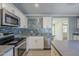 Updated kitchen features stainless steel appliances, gray quartz countertops, and stylish tile backsplash at 7135 W Flower St, Phoenix, AZ 85033