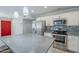 Bright kitchen boasts stainless steel appliances, gray quartz countertops, mosaic backsplash and red door at 7135 W Flower St, Phoenix, AZ 85033