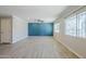 Open living room with wood-look tile flooring, a ceiling fan, and expansive windows for abundant natural light at 7135 W Flower St, Phoenix, AZ 85033