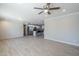 Bright living room featuring wood-look tile floors, a ceiling fan, and an open layout leading to the kitchen at 7135 W Flower St, Phoenix, AZ 85033